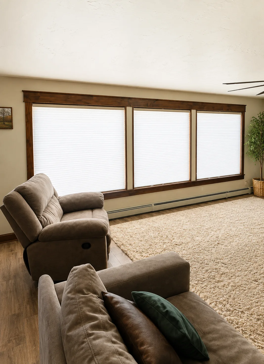 White cellular shades across three large living room windows