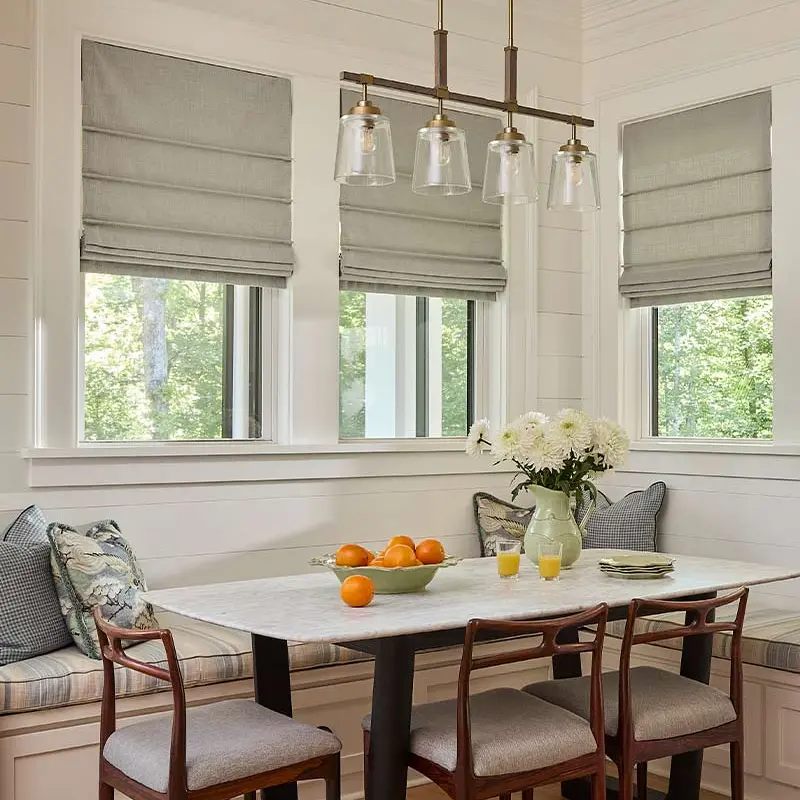Gray roman shades in a bright breakfast nook